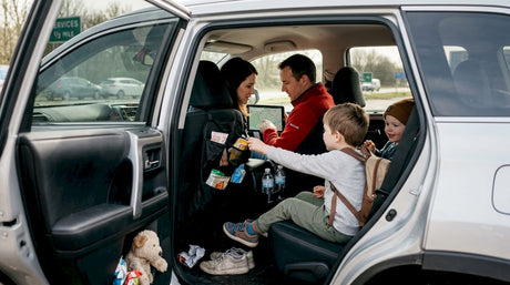 Family organizing snacks during road trip break